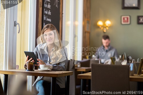 Image of Pregnant Woman With Digital Tablet At Table