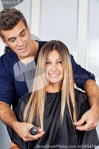 Image of Woman With Hairdresser Measuring Her Hair At Salon