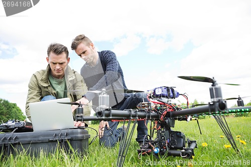 Image of Engineers Using Laptop By UAV Octocopter