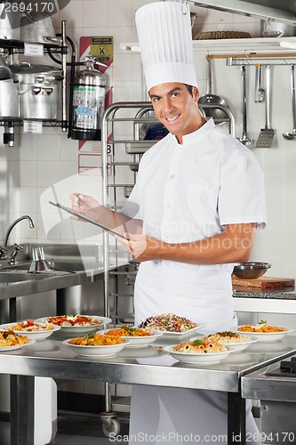 Image of Male Chef With Clipboard At Kitchen