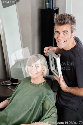 Image of Customer With Hairdresser Holding Mirror