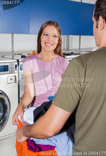 Image of Man And Woman Carrying Basket Of Clothes