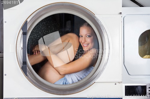 Image of Mischievous Woman Sitting Inside Washing Machine