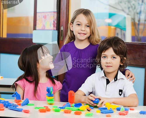 Image of Girl With Friends Playing Blocks In Classroom