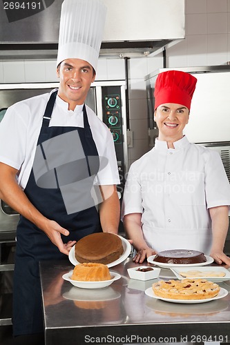 Image of Happy Chefs With Variety Of Sweet Dishes