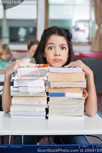 Image of Angry Schoolgirl Resting Chin On Books