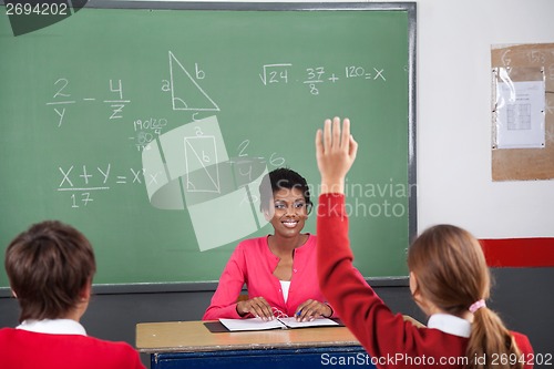 Image of Teenage Girl Raising Hand While Teacher Looking At Her