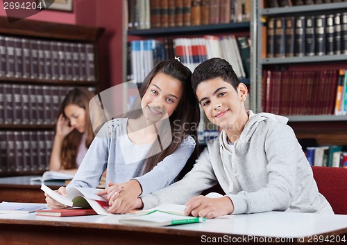 Image of Girlfriend And Boyfriend Holding Hands At Table In School Librar