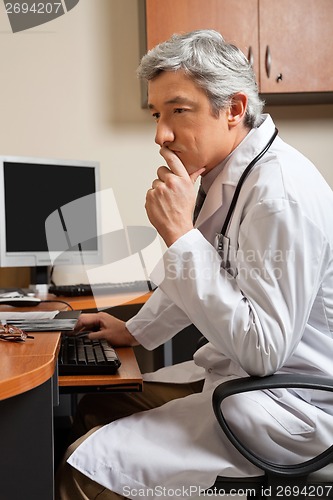 Image of Pensive Doctor Sitting At Desk