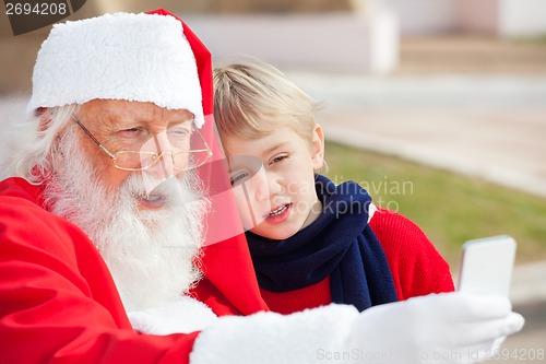 Image of Santa Claus And Boy Taking Selfportrait Through Smartphone