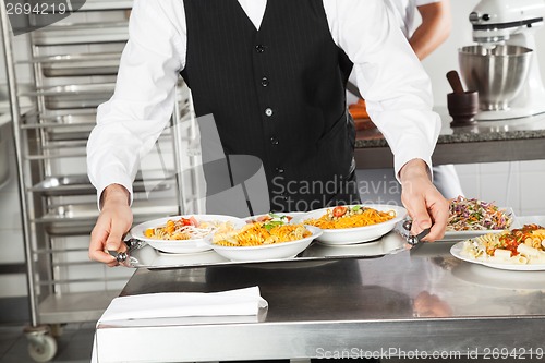 Image of Waiter Holding Pasta Dishes In Tray