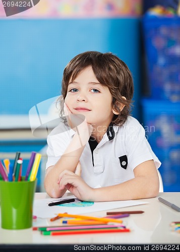 Image of Boy Sitting With Hand On Chin In Drawing Class