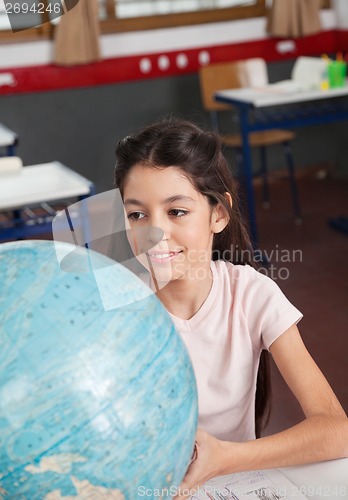 Image of Schoolgirl Smiling While Searching Places On Globe