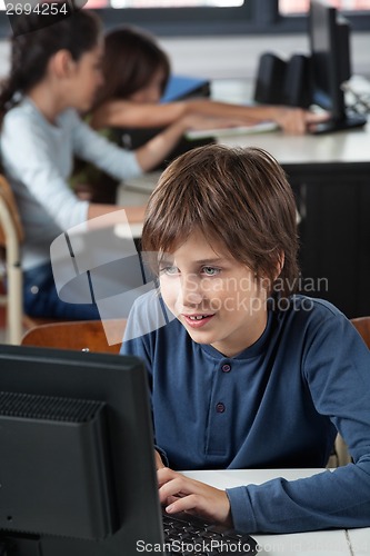 Image of Schoolboy Using Computer At Desk