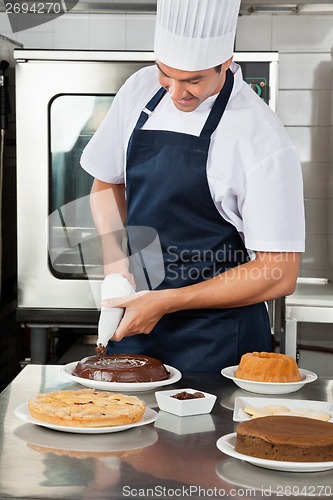 Image of Chef decorating sweet food with piping bag