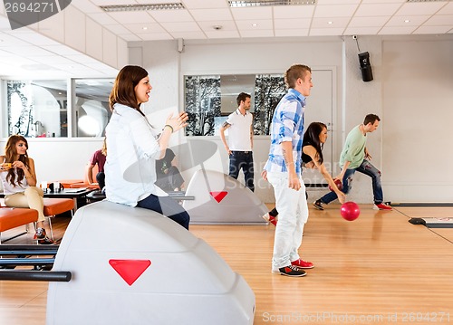Image of Young Friends Bowling in Club