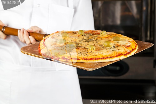 Image of Chef Holding Pizza On Shovel