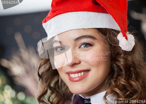 Image of Beautiful Woman Wearing Santa Hat In Christmas Store