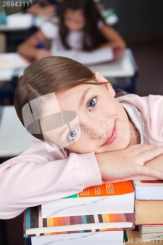 Image of Happy Schoolgirl Leaning On Stack Of Books