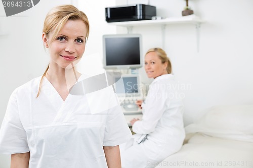 Image of Happy Female Gynecologist With Colleague In Background