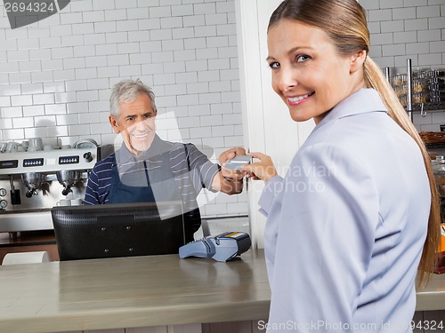 Image of Female Customer Making Payment Through Credit Card In Store