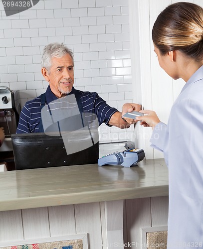 Image of Customer Giving Credit Card To Cashier At Store