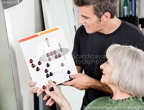 Image of Woman With Male Hair Stylist Selecting Hair Color