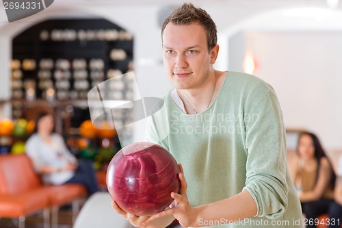 Image of Man Holding Bowling Ball in Club