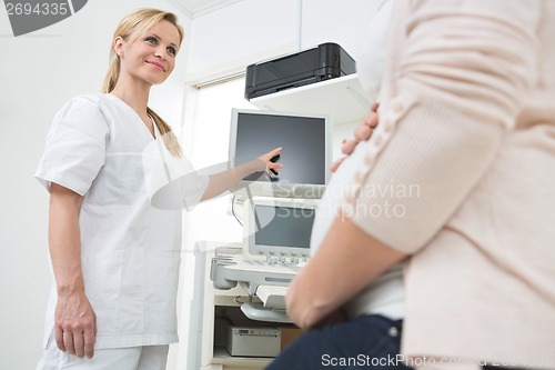 Image of Doctor Showing Ultrasound Scan To Pregnant Woman