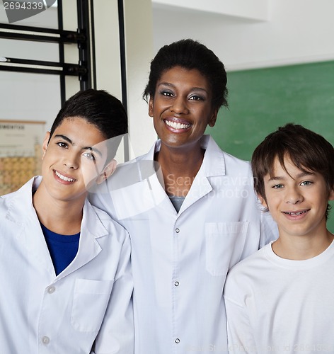 Image of Teacher Standing With Male Students In Lab