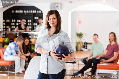 Image of Confident Young Woman With Bowling Ball in Club