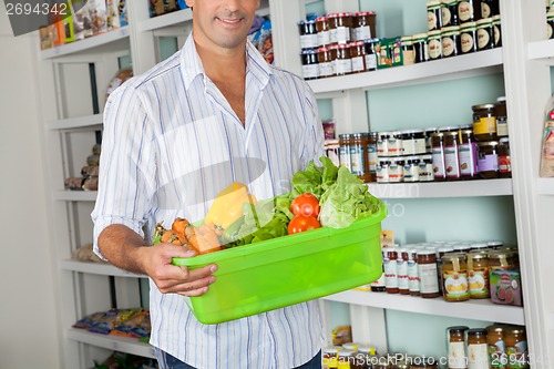 Image of Man With Basket Of Fresh Vegetables Standing In Store