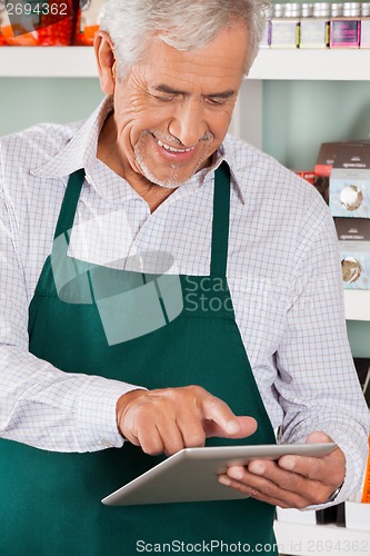 Image of Owner Using Digital Tablet In Grocery Store