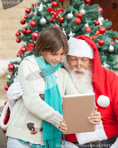 Image of Boy Showing Digital Tablet To Santa Claus