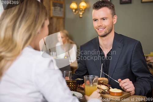 Image of Businessman Having Meal With Female