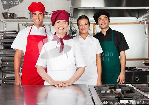 Image of Happy Chefs Standing Together In Kitchen