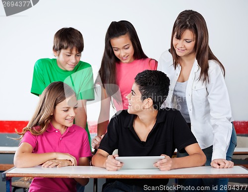 Image of University Students Using Digital Tablet At Desk