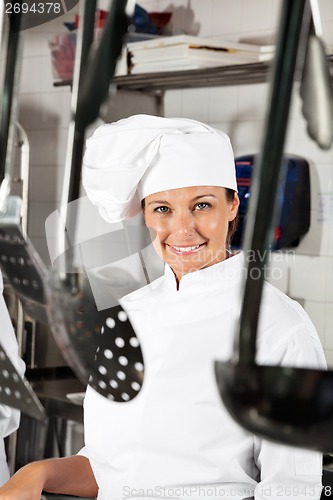 Image of Female Chef With Spoons Hanging In Foreground