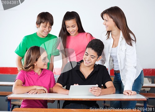Image of Teenage Boys And Girls Using Digital Tablet At Desk