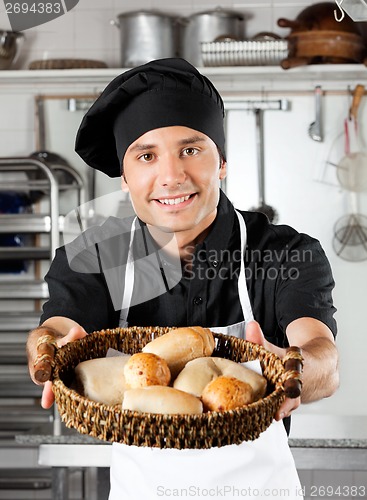 Image of Male Chef Offering Breads In Kitchen