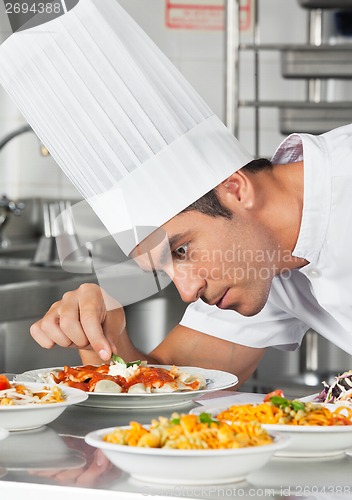 Image of Chef Garnishing Pasta Dishes