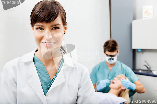 Image of Female Assistant With Dentist Working In The Background