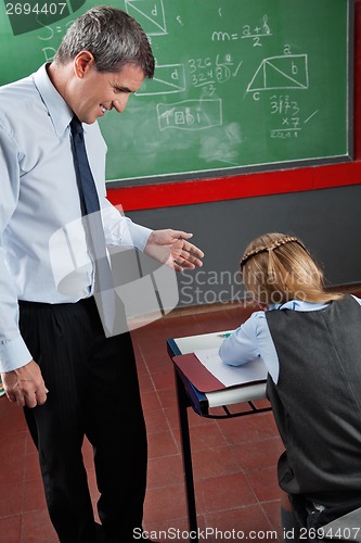 Image of Professor Looking At Schoolgirl In Classroom