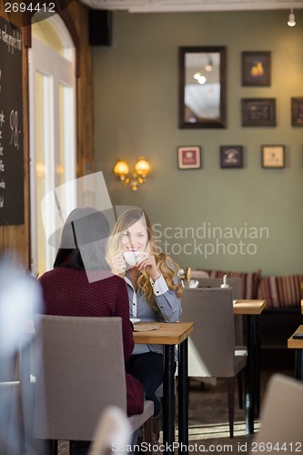 Image of Young Woman Drinking Coffee With Female Friend