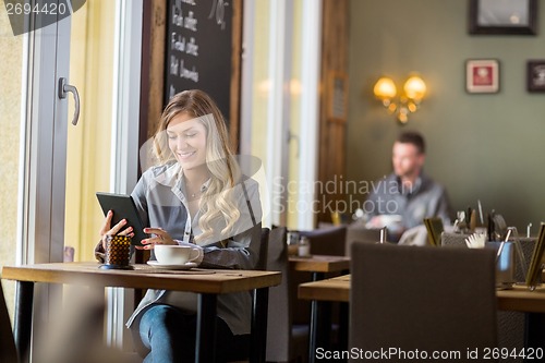 Image of Pregnant Woman Using Digital Table In Cafe