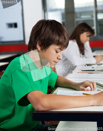 Image of Schoolboy Studying At Desk In Classroom