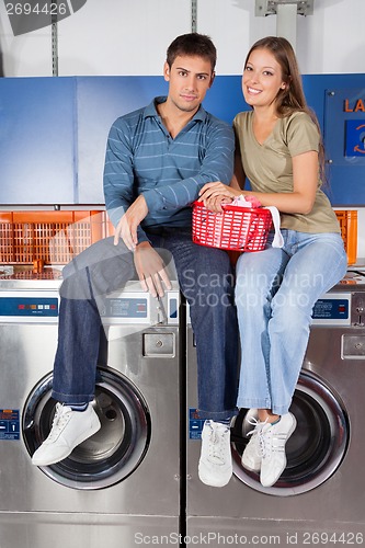 Image of Couple Sitting On Washing Machines