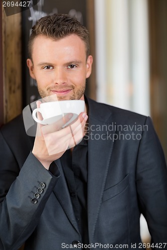 Image of Confident Business Man Drinking Coffee