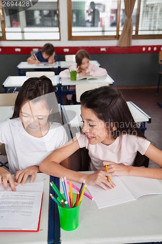Image of Schoolgirls Studying Together In Classroom
