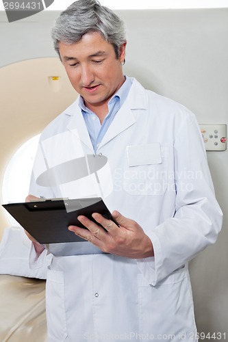 Image of Doctor Writing On Clipboard